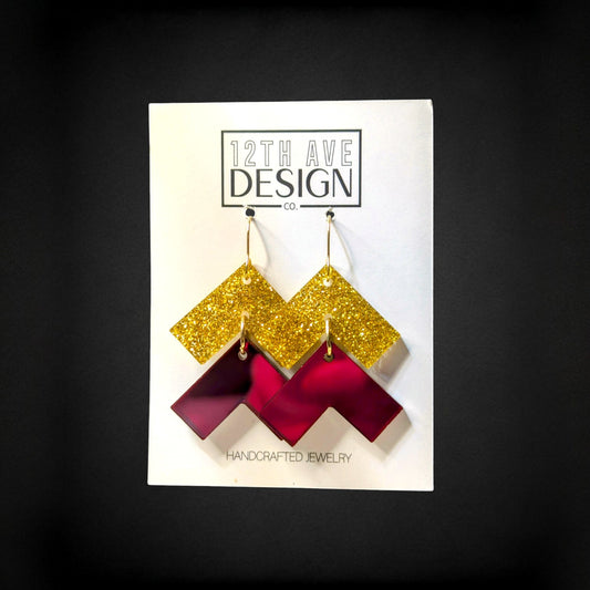 12th Ave Design Co. chevron earrings with gold glitter and maroon acrylic geometric drops on surgical steel hooks.