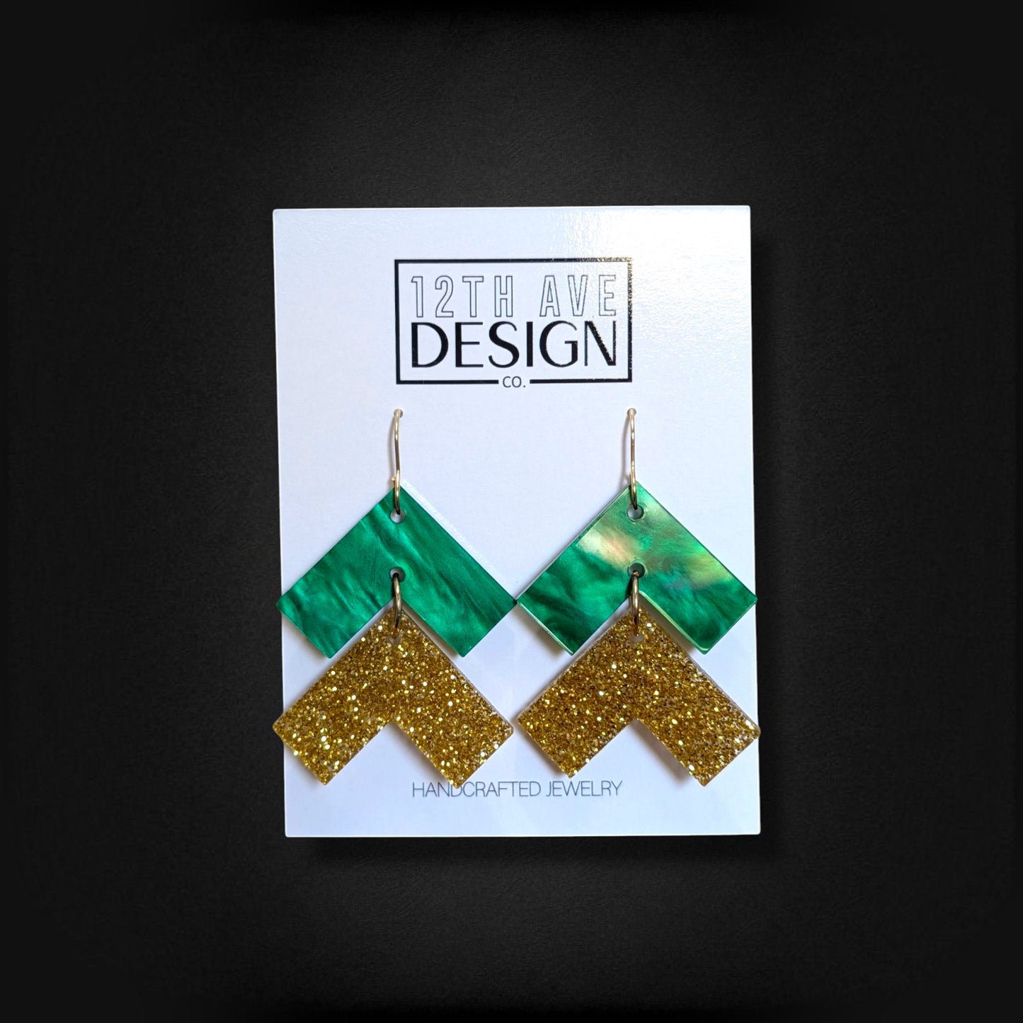 12th Ave Design Co. green and gold glitter chevron drop earrings with surgical steel hooks on display card