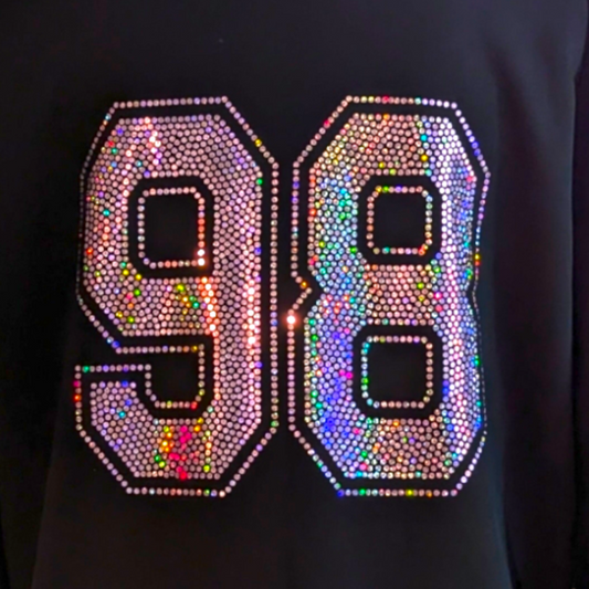 A black crop sweatshirt with the number 98 in pink or silver sparkly jersey-style text, mid-length fit, side-seamed.