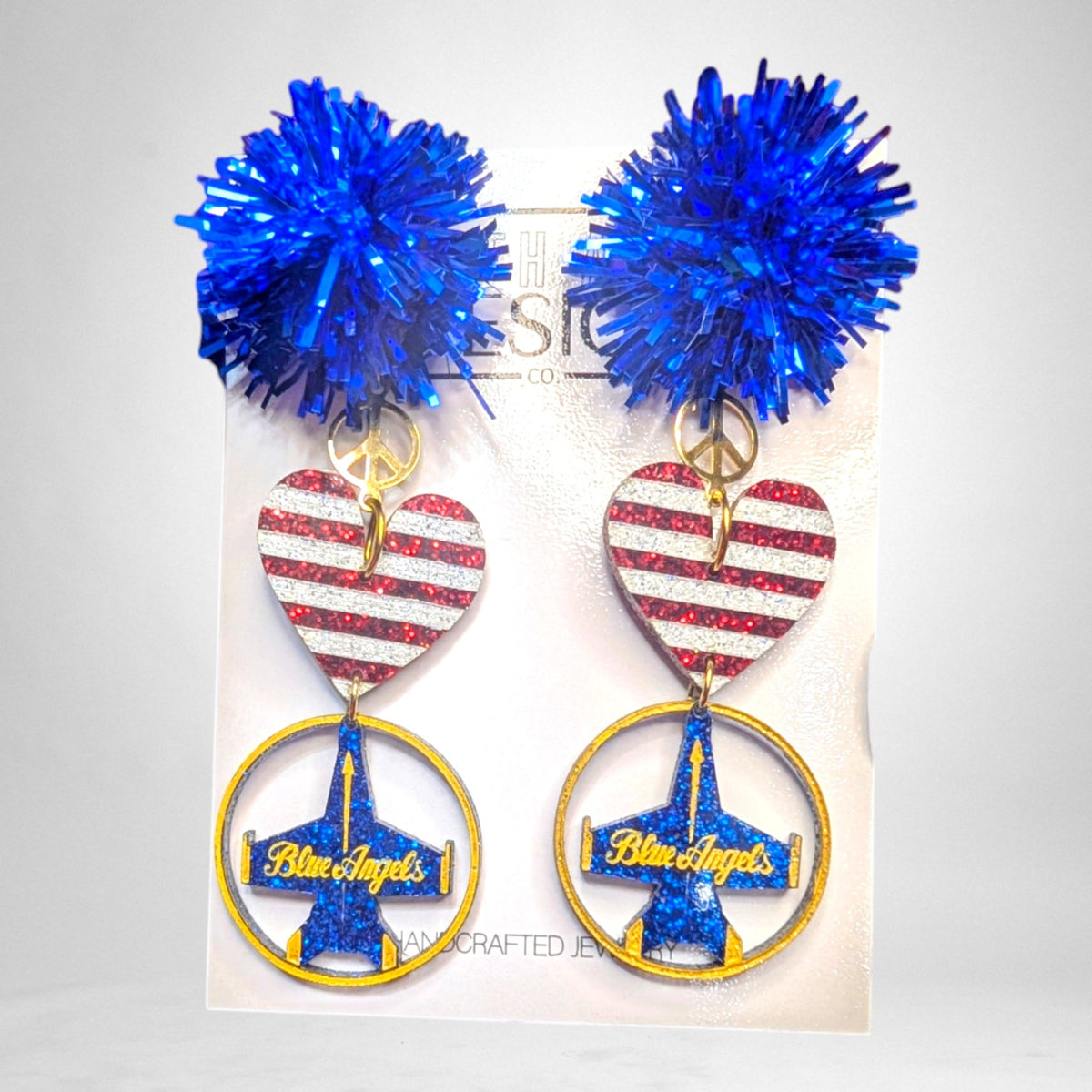 12th Ave Design Co. custom Blue Angels earrings featuring blue pom-poms, glittery American flag hearts, and jet charms.