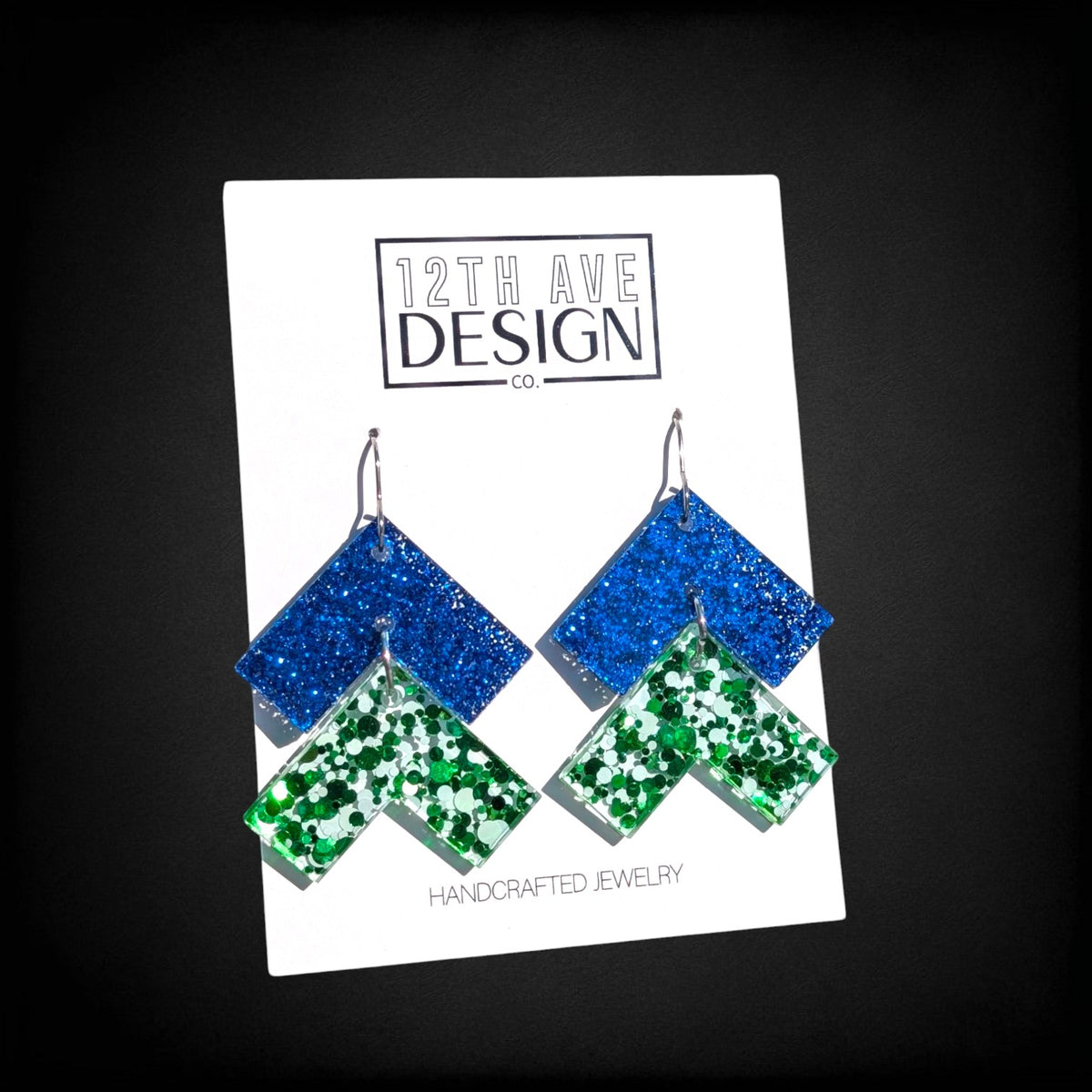 12th Ave Design Co. blue and green glitter chevron drop earrings on surgical steel hooks with geometric design.