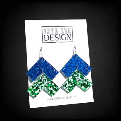 12th Ave Design Co. blue and green glitter chevron drop earrings on surgical steel hooks with geometric design.