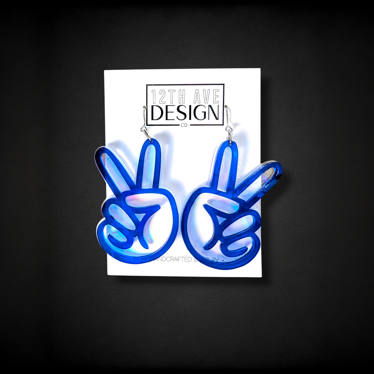 12th Ave Design Co. blue translucent peace sign hand earrings with iridescent shimmer. 2.5" drop.