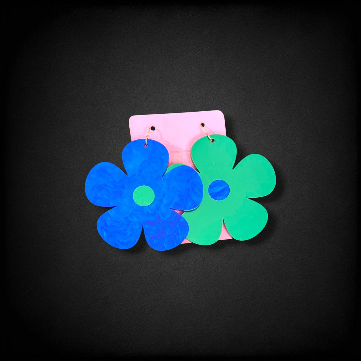 12th Ave Design Co. Bubble Daisy earrings featuring large blue and green flower-shaped acrylic dangles on hooks.