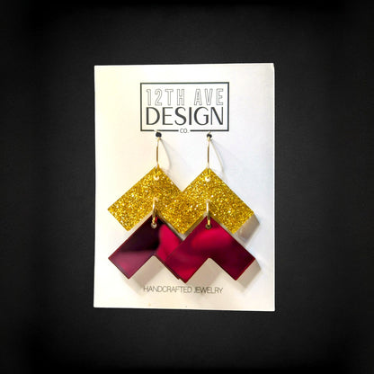 12th Ave Design Co. chevron earrings with gold glitter and maroon acrylic geometric drops on surgical steel hooks.