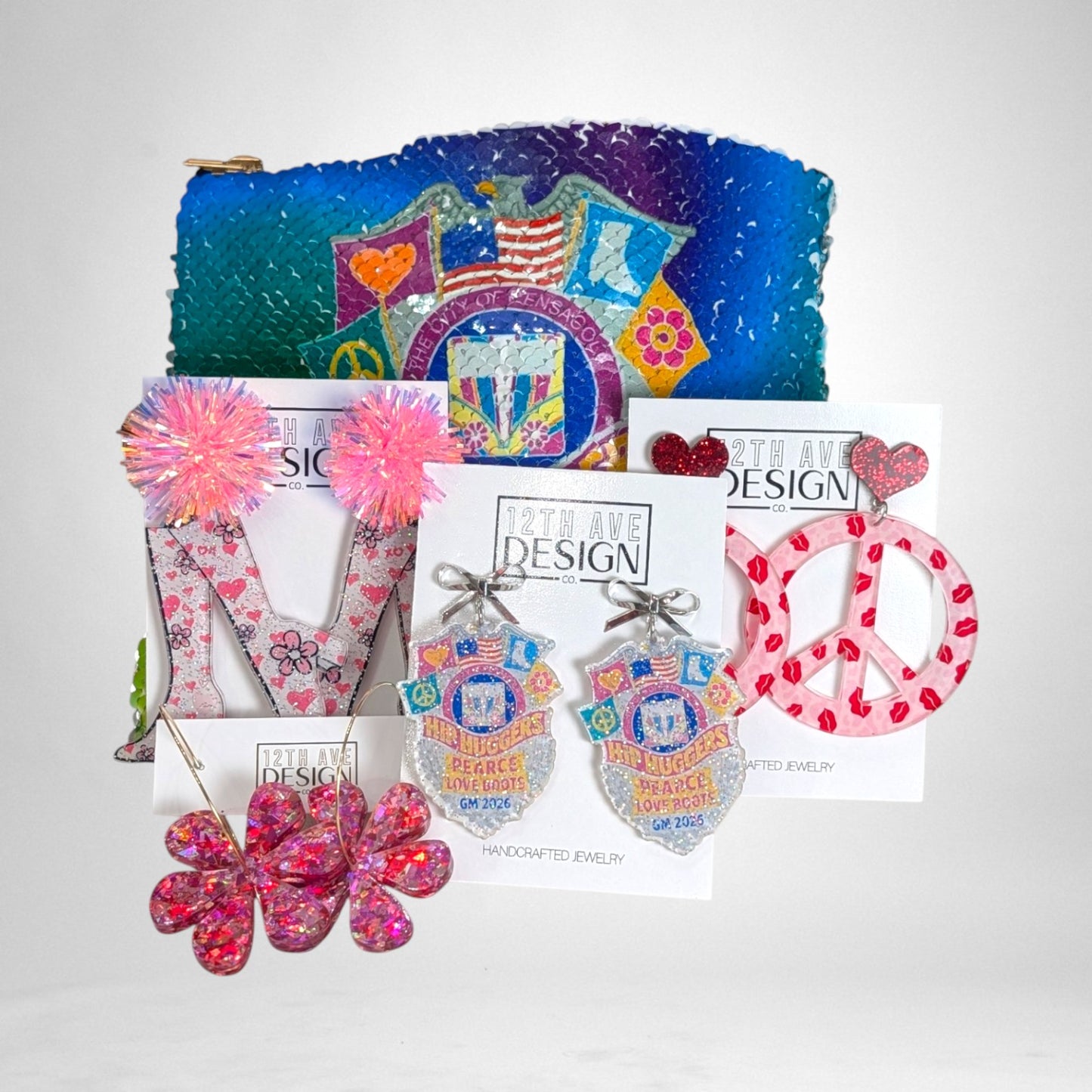 12th Ave Design Co. custom acrylic earrings featuring floral, peace sign, and badge designs with glitter accents.
