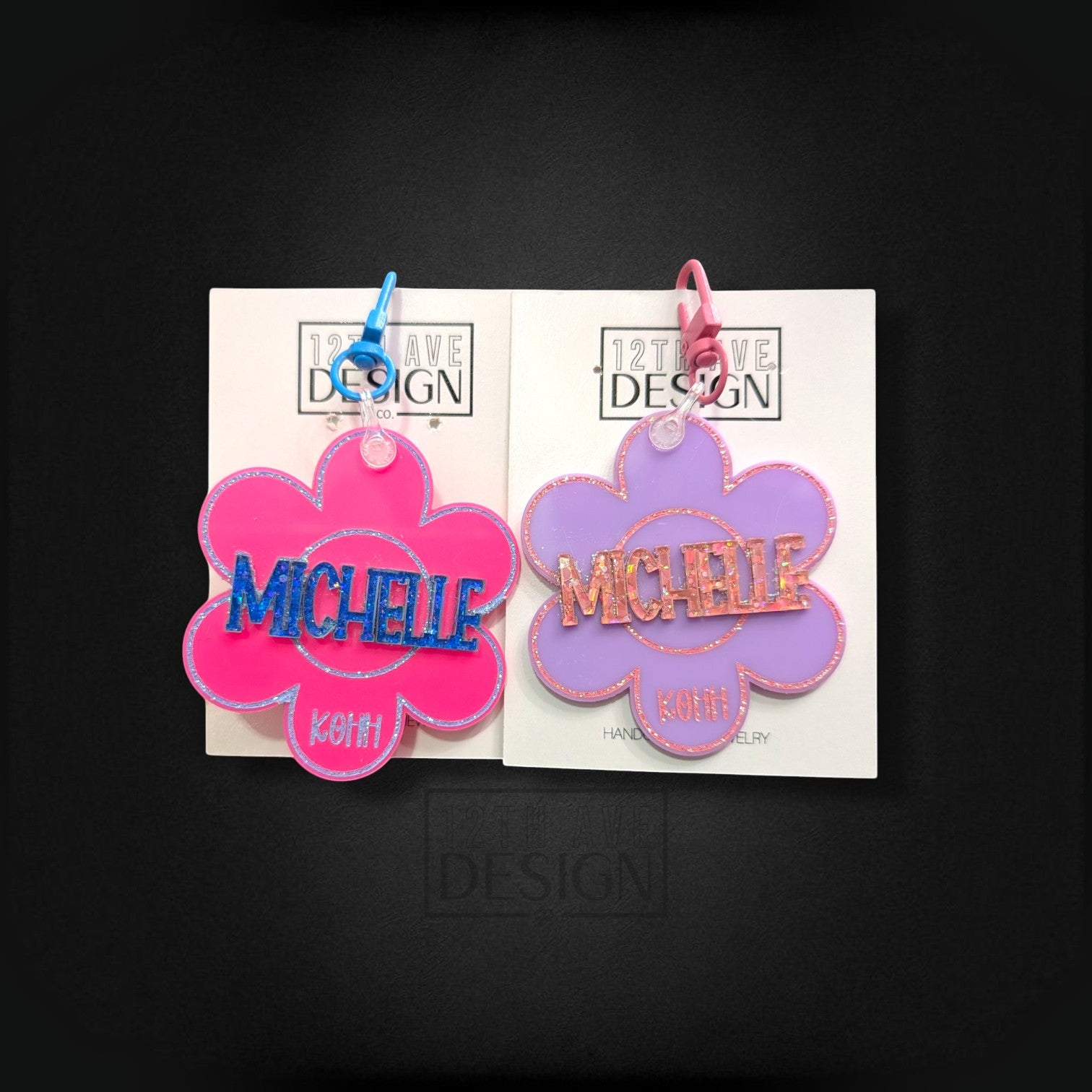 12th Ave Design Co. custom flower-shaped acrylic keychains with glitter name accents and colorful plastic clips.