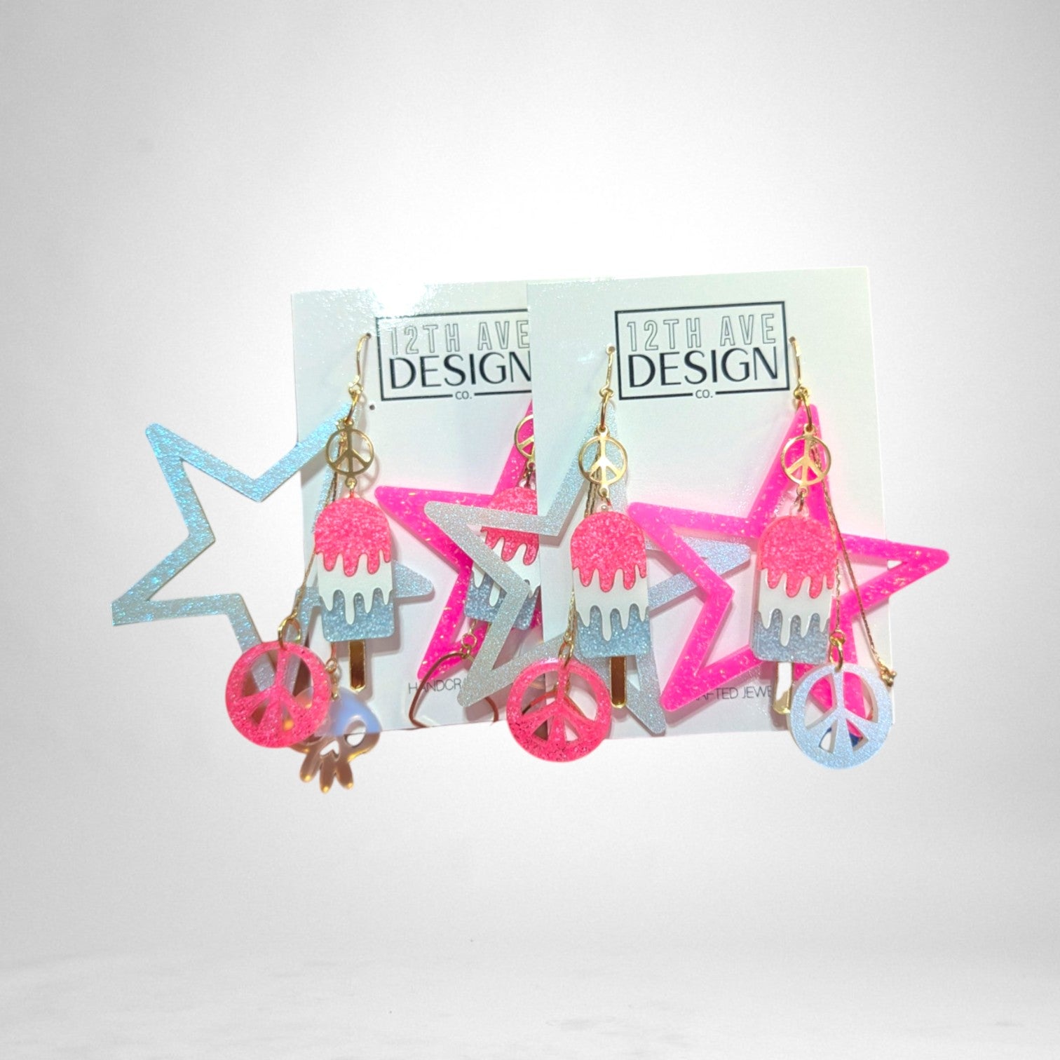 12th Ave Design Co. custom glittery star and popsicle earrings with peace sign charms in pink and blue