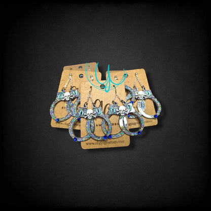 12th Ave Design Co. custom glittery skull earrings with blue accents on display cards for special events.