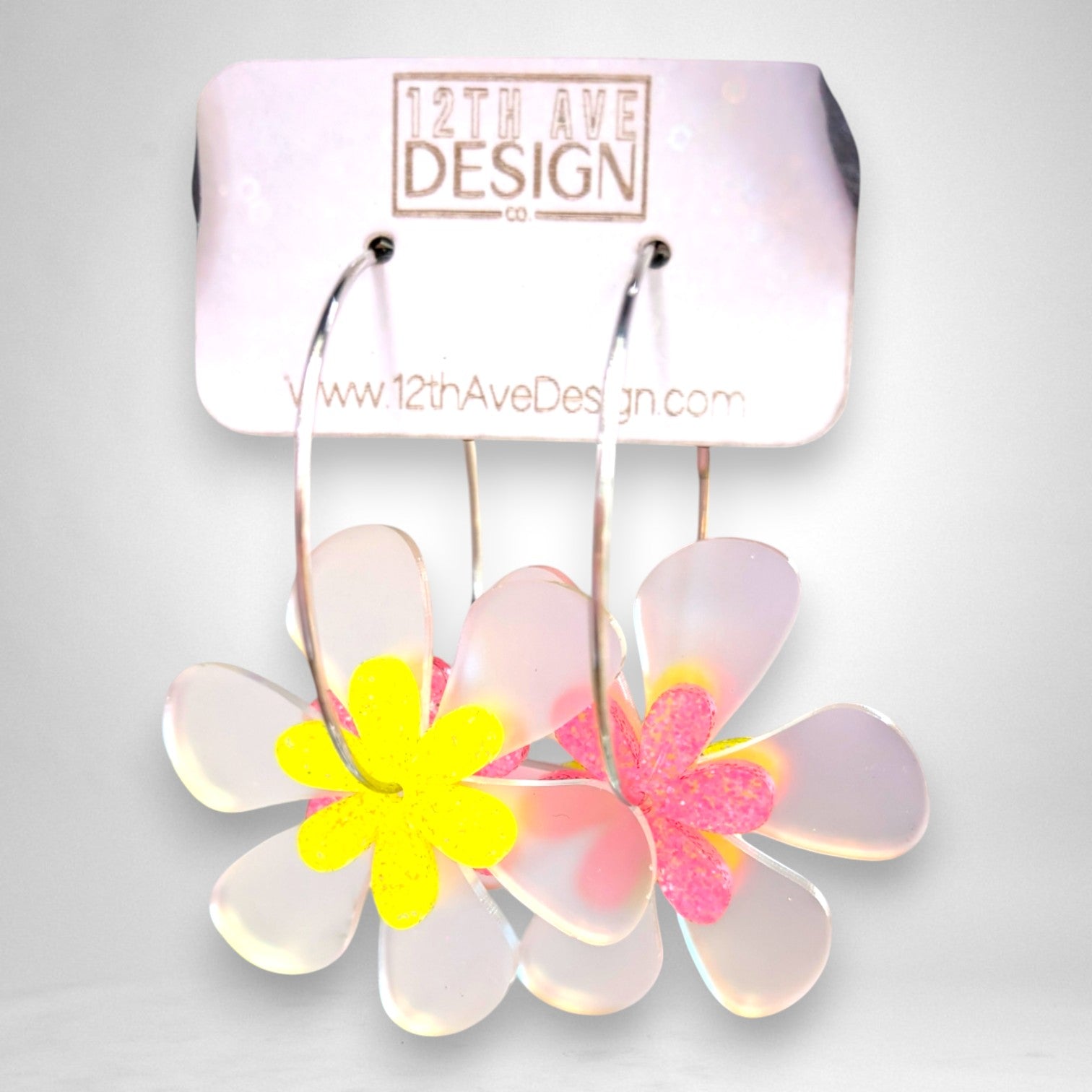 12th Ave Design Co. floating daisy hoop earrings with translucent petals and glittery yellow and pink centers