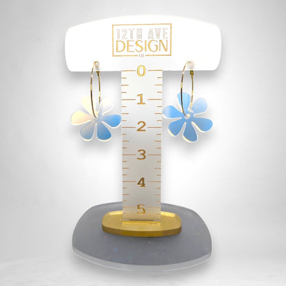 12th Ave Design Co. floating daisy hoop earrings with iridescent acrylic flower charms on gold-plated hoops.