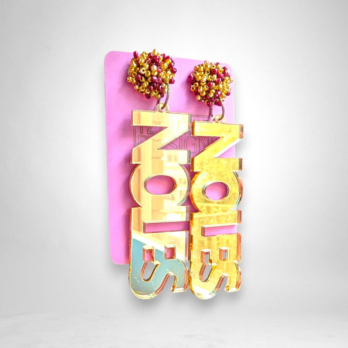 12th Ave Design Co. gold mirror acrylic Noles block text earrings with maroon and gold seed bead pom accents.