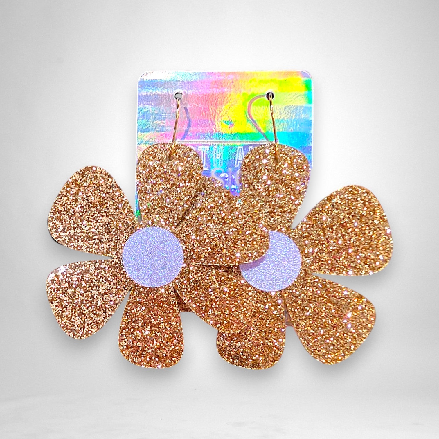 12th Ave Design Co. gold glitter flower statement earrings with a large groovy floral design on a holographic card