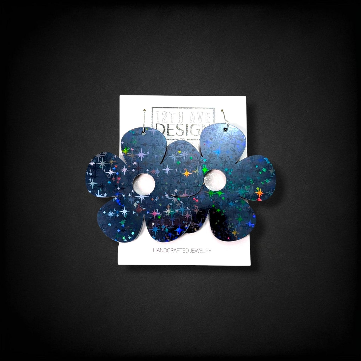 12th Ave Design Co. Bubble Daisy earrings featuring a dark holographic star pattern on large five-petal flowers.