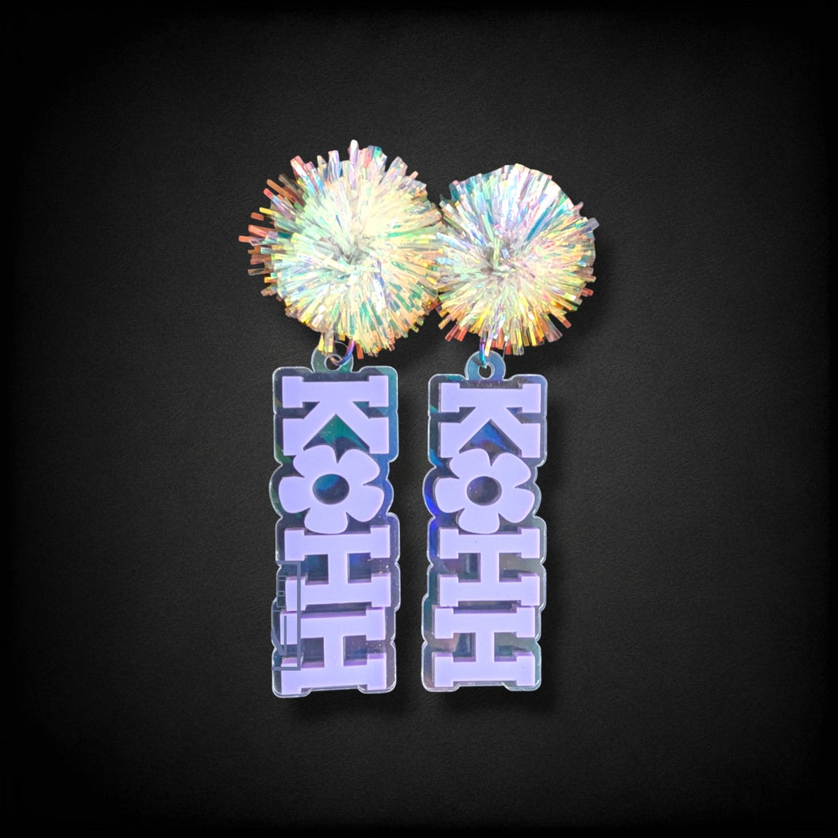 12th Ave Design Co. KOHH Varsity Bloom earrings featuring iridescent acrylic pom-poms and engraved lettering.