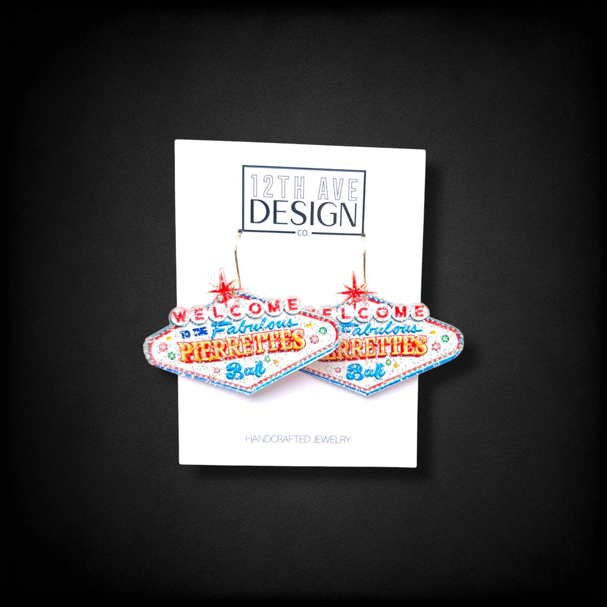 12th Ave Design Co. custom Las Vegas sign style earrings with glitter and red star accents on a display card.
