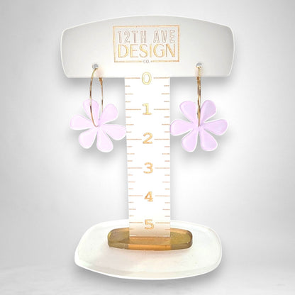12th Ave Design Co. floating daisy hoop earrings featuring light purple acrylic flower charms on gold-plated hoops.