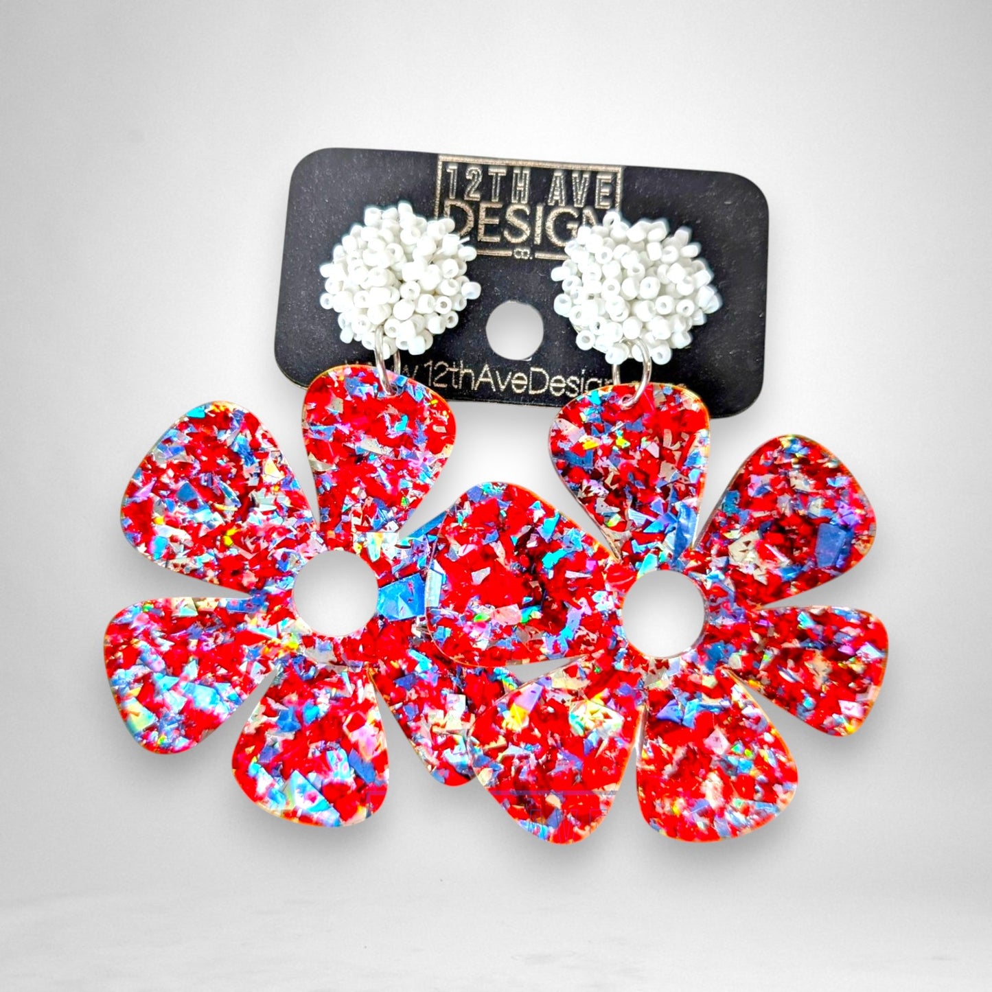 12th Ave Design Co. Flower Power statement earrings featuring red glitter acrylic petals and white beaded studs.