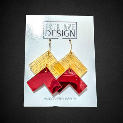 12th Ave Design Co. chevron earrings featuring gold textured squares and red glossy geometric drops on steel hooks.