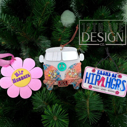 12th Ave Design Co. set of three retro-themed holiday ornaments featuring a pink flower, a glittery bus, and a sign.