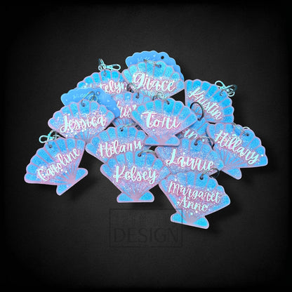 12th Ave Design Co. custom blue glitter seashell keychains with white cursive names for a group event.