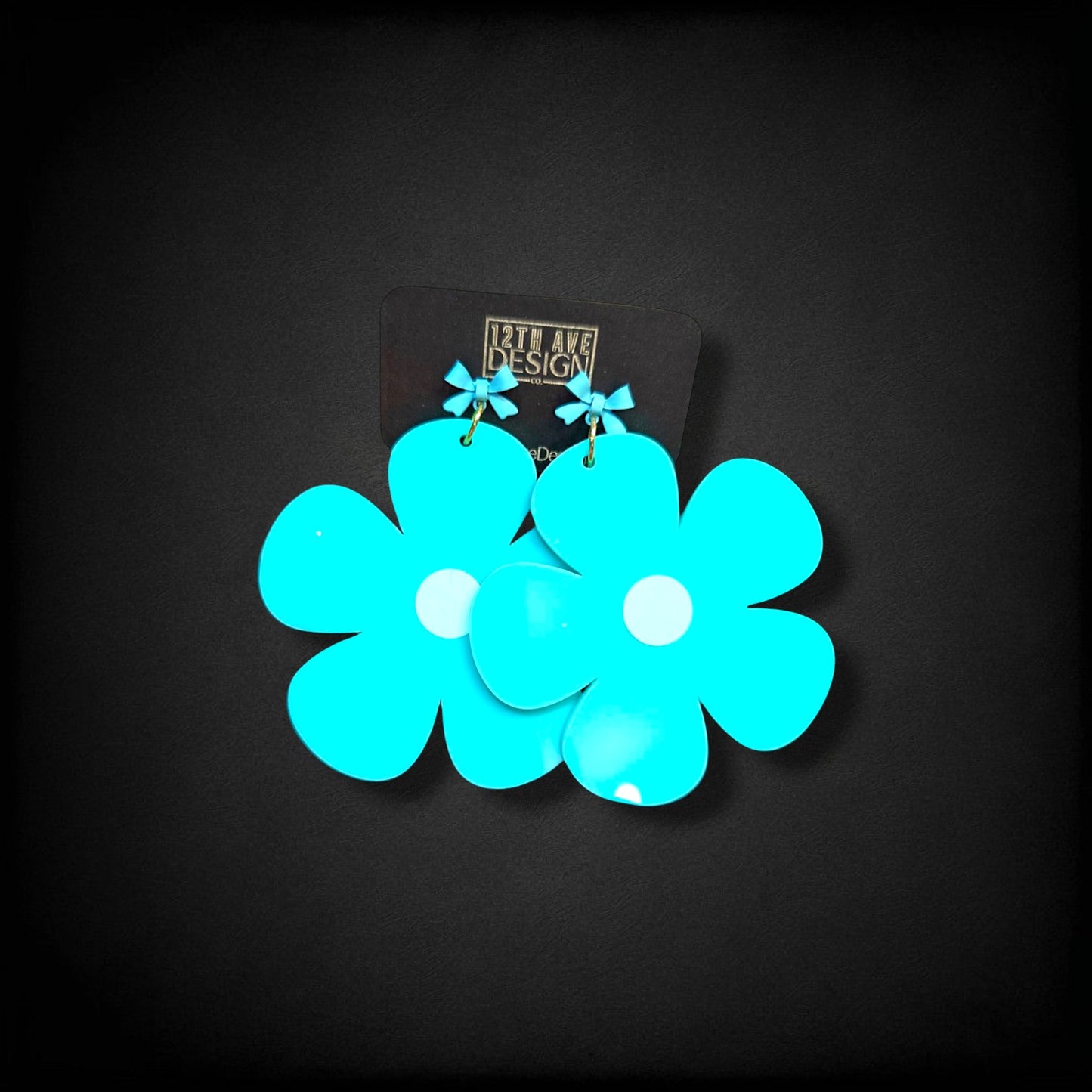 12th Ave Design Co. bright turquoise bubble daisy earrings with small bow accents and modern gold-plated hooks.
