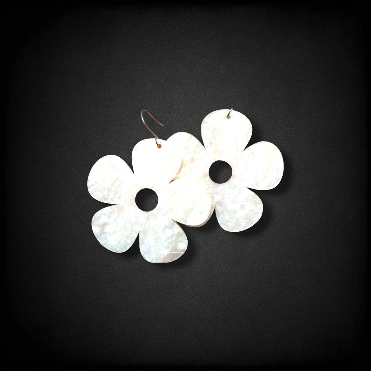 12th Ave Design Co. white iridescent bubble daisy earrings with five petals and modern hooks on a black background.