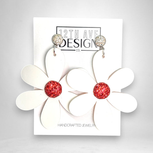 12th Ave Design Co. statement floral earrings featuring white acrylic petals and a sparkling red crystal center.